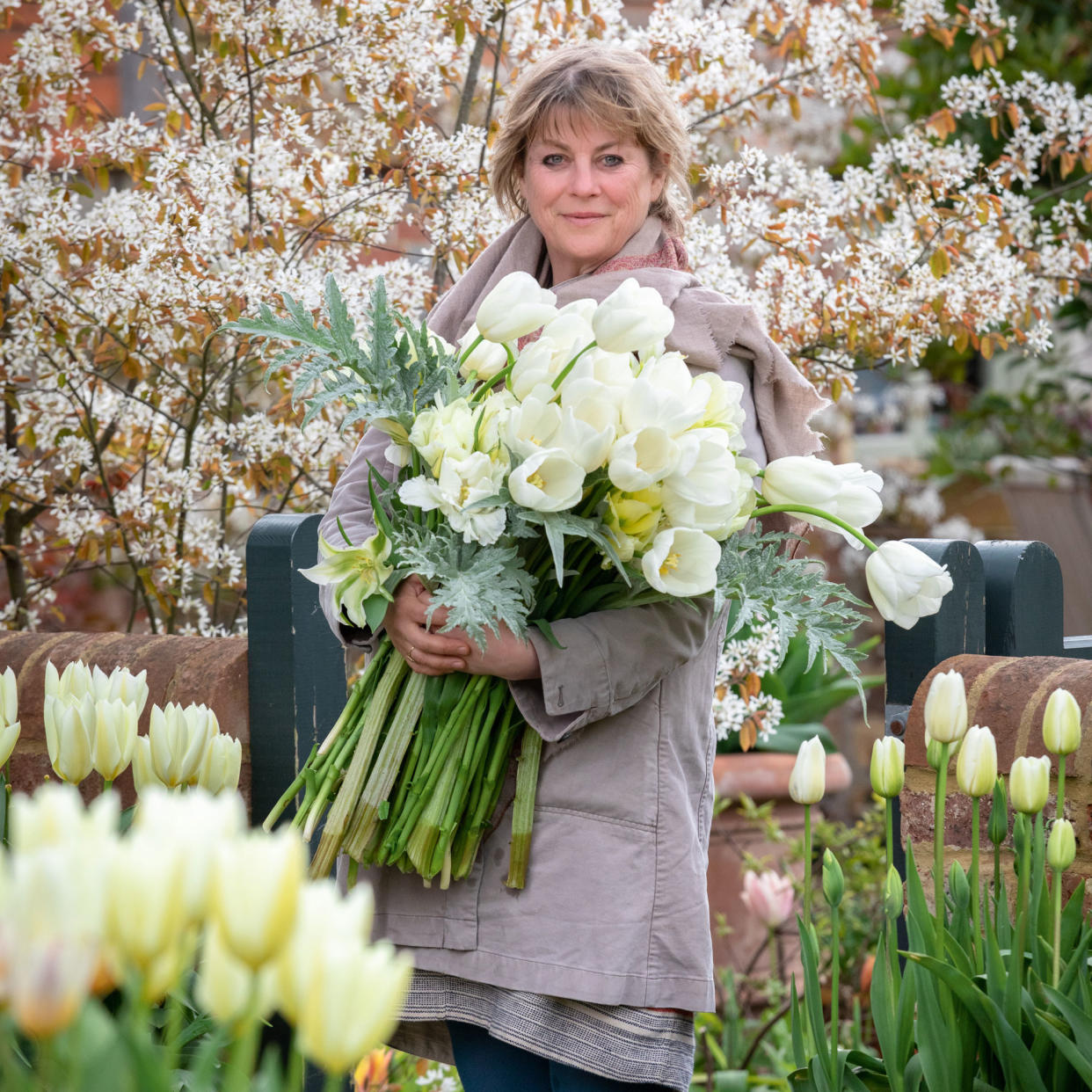  gardens expert Sarah Raven holding a large bunch of white tulips 