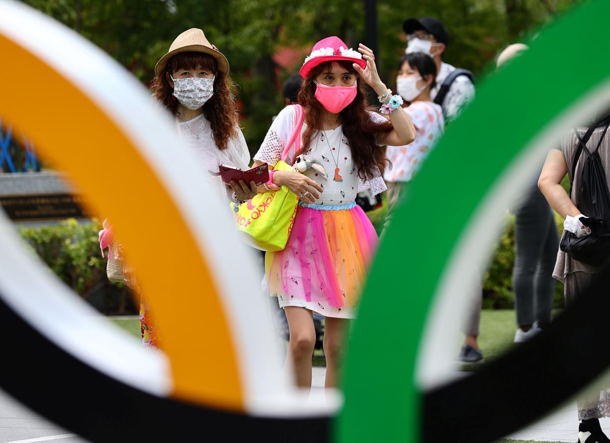 People wearing protective face masks amid the coronavirus disease outbreak visit an Olympic Ring outside the National Stadium, the main venue of the Tokyo 2020 Olympic Games (REUTERS)