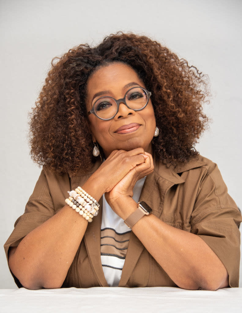 headshot of Oprah, she has her hands propping up her chin