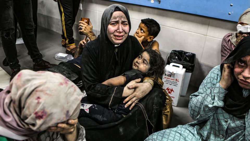 Wounded women and children sit on the floor at the Al-Shifa Hospital after being transported from the Al-Ahli Baptist Hospital following a blast there on Tuesday, October 17. - Abed Khaled/AP