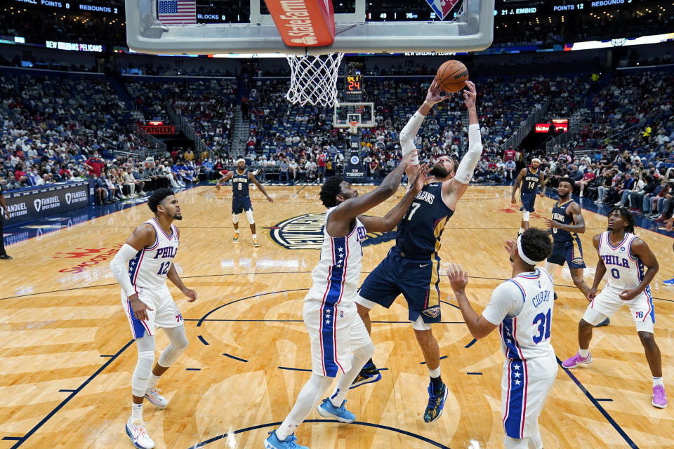 New Orleans Pelicans center Jonas Valanciunas pulls down an offensive rebound against Philadelphia 76ers center Joel Embiid in the first half of an NBA basketball game in New Orleans, Wednesday, Oct. 20, 2021. (AP Photo/Gerald Herbert)