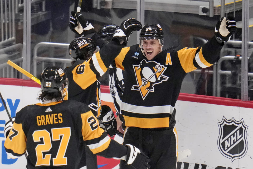 Pittsburgh Penguins' Evgeni Malkin (71) celebrates with Rickard Rakell (67) and Ryan Graves after scoring during the first period of an NHL hockey game against the Buffalo Sabres in Pittsburgh, Saturday, Nov. 11, 2023. (AP Photo/Gene J. Puskar)