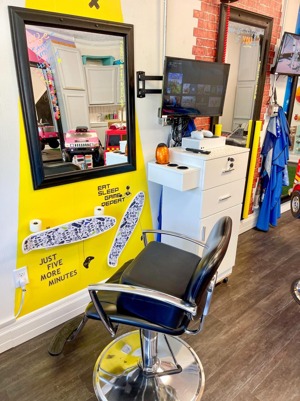 Children can play video games or watch television while they have their hair cut at Brave Little Clippers in Fountain City on Aug. 3, 2022. The capes come with a transparent window so they can see their hands and controller.