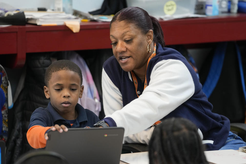 Santrice Sanchez works with second grader Denzel Daggs, 7, at Schaumburg Elementary, part of the ReNEW charter network, in New Orleans, Wednesday, April 19, 2023. (AP Photo/Gerald Herbert)