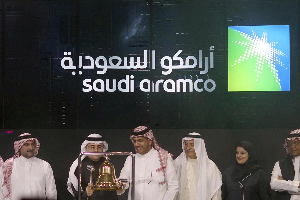 FILE - In this Dec. 11, 2019, file photo, Saudi Arabia's state-owned oil company Armco and stock market officials celebrate during the official ceremony marking the debut of Aramco's initial public offering (IPO) on the Riyadh's stock market, in Riyadh, Saudi Arabia. Saudi Arabia's oil and gas giant Aramco announced Tuesday, Nov. 3, 2020, third quarter profits of nearly $12 billion, a significantly higher net income from its dramatically lower second quarter earnings. (AP Photo/Amr Nabil, File)