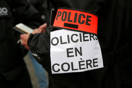 A French policeman wears an arm band with the slogan "Angry policemen" during a protest against anti-police violence on a bridge over the river Seine in Paris, France, October 26, 2016. REUTERS/Charles Platiau