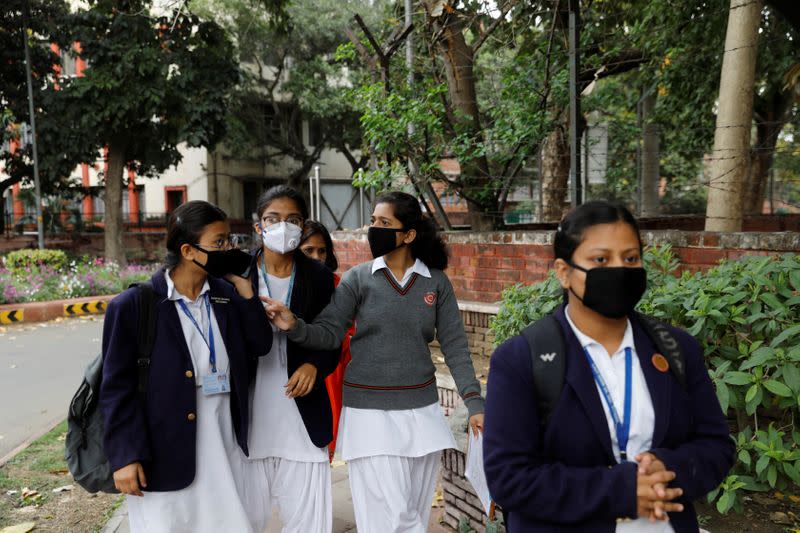 Students wearing protective masks leave after taking their exams in New Delhi