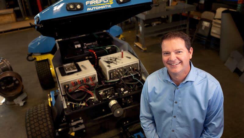 Matt Aposhian, president and COO of FireFly Automatix, stands beside a fully autonomous lawn mower at FireFly Automatix in Salt Lake City on Wednesday, March 13, 2024.