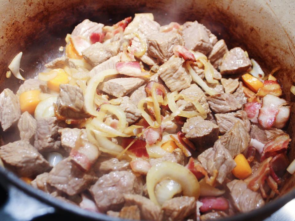 beef bacon onions and carrots in the dutch oven