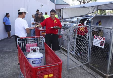 Hawaii residents line up to fill their propane tanks at a local hardware store as a hurricane and a tropical storm approach the Hawaiian islands, in Mililani, Hawaii, August 5, 2014. REUTERS/Hugh Gentry