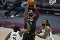 Cleveland Cavaliers' Andre Drummond (3) drives to the basket against Brooklyn Nets' James Harden (13) and DeAndre Jordan (6) during the first half of an NBA basketball game Friday, Jan. 22, 2021, in Cleveland. (AP Photo/Tony Dejak)