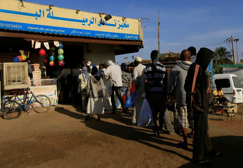 Customers queue to buy bread at a bakery in Khartoum