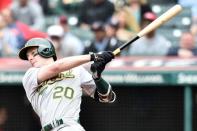 May 22, 2019; Cleveland, OH, USA; Oakland Athletics designated hitter Mark Canha (20) hits an RBI fielders choice during the first inning against the Cleveland Indians at Progressive Field. Mandatory Credit: Ken Blaze-USA TODAY Sports