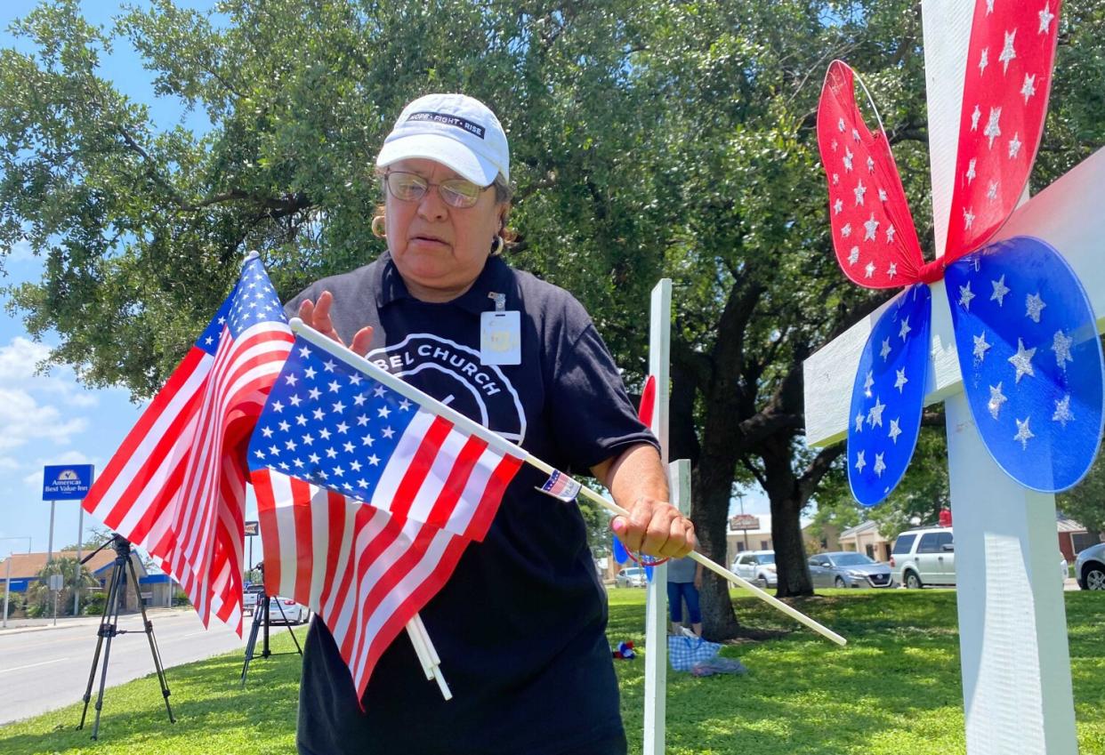 A woman holds American flags.