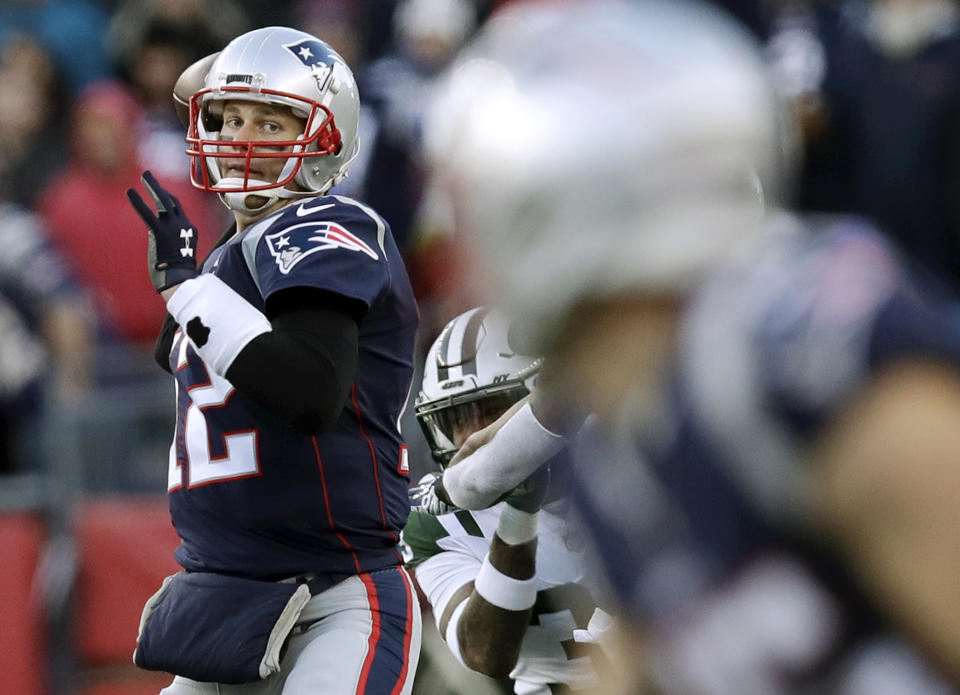 New England Patriots quarterback Tom Brady, left, drops back to pass to wide receiver Chris Hogan, foreground, during the second half of an NFL football game against the New York Jets, Sunday, Dec. 30, 2018, in Foxborough, Mass. The completion was Brady's 6,000th during his career. (AP Photo/Charles Krupa)