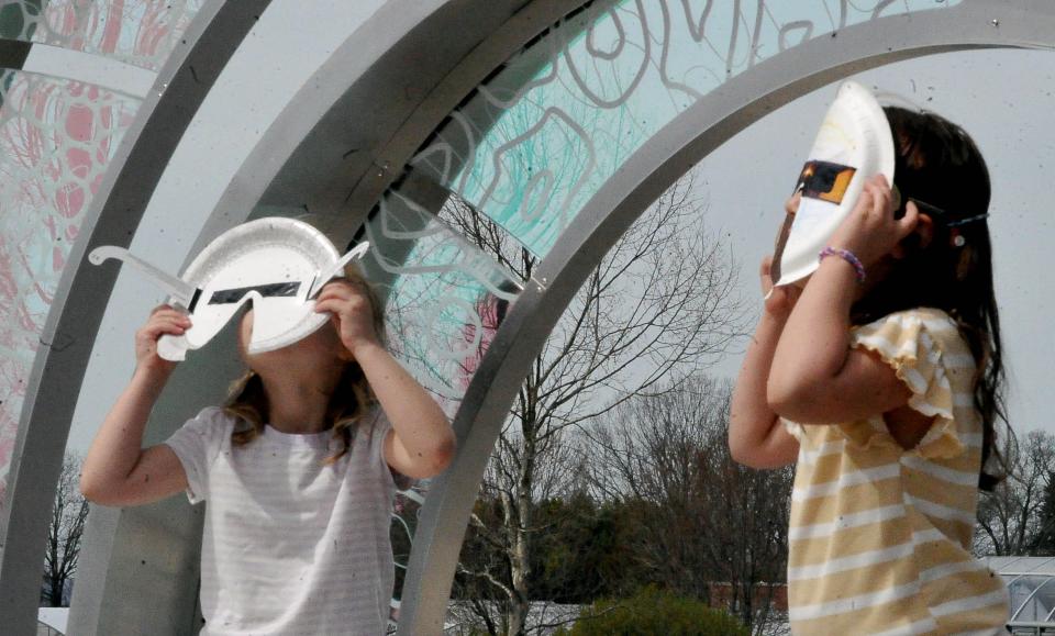 Sisters Leanna and Lesedi Tieszen of Millersburg use their special design solar glssses to watch the elcipse.