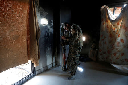 A fighter of Syrian Democratic Forces inspects an RPG at his position inside a building at the frontline in Raqqa, Syria October 16, 2017. REUTERS/Erik De Castro