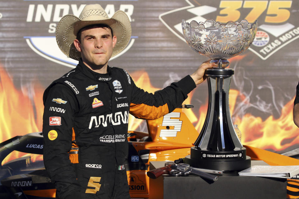 Pato O'Ward posa con el trofeo tras ganar la carrera de la IndyCar en Texas Motor Speedway, el domingo 2 de mayo de 2021, en Fort Worth, Texas. (AP Foto/Richard W. Rodríguez)