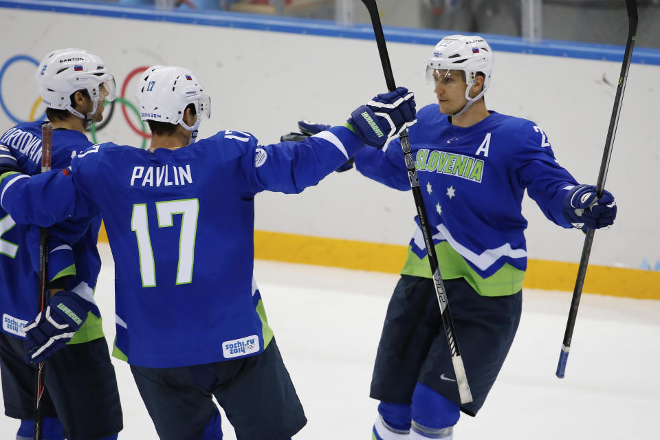 Slovenia forward Marcel Rodman, right, celebrates his goal against the United States with teammates David Rodman and Ziga Pavlin during the 2014 Winter Olympics men's ice hockey game at Shayba Arena Sunday, Feb. 16, 2014, in Sochi, Russia. USA defeated Slovenia 5-1. (AP Photo/Petr David Josek)