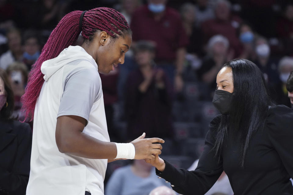 South Carolina forward Aliyah Boston, left, receives an SEC championship ring from coach Dawn Staley before the team's NCAA college basketball game against Clemson on Wednesday, Nov. 17, 2021, in Columbia, S.C. (AP Photo/Sean Rayford)