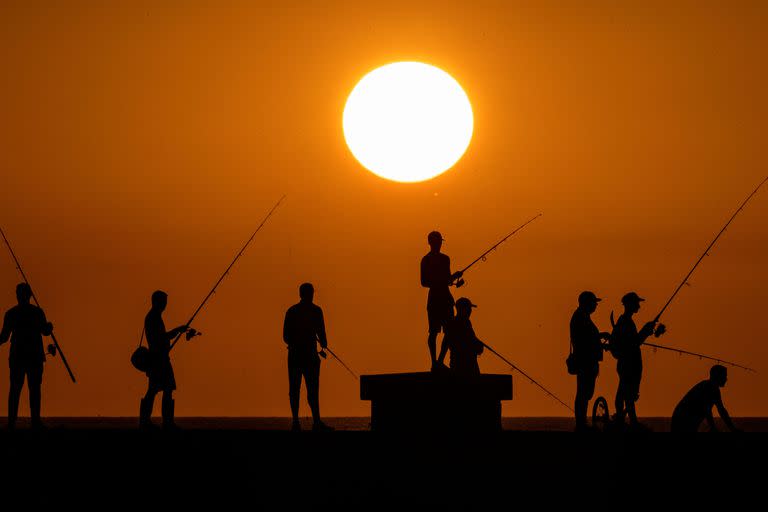 Personas pescan al atardecer en el malecón de La Habana el 6 de julio de 2023