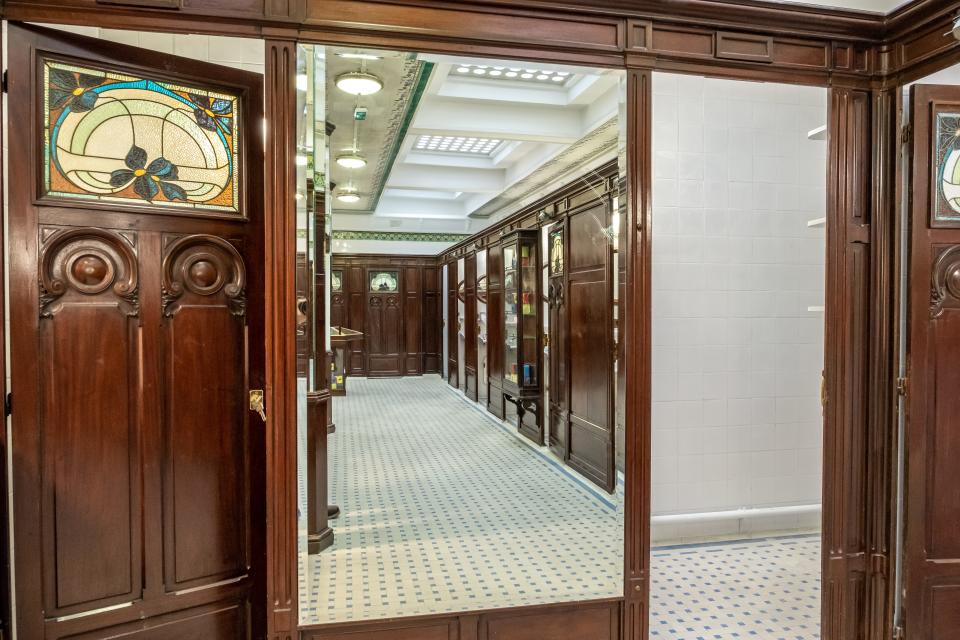 A mirror reflects the tiled interior of the restroom