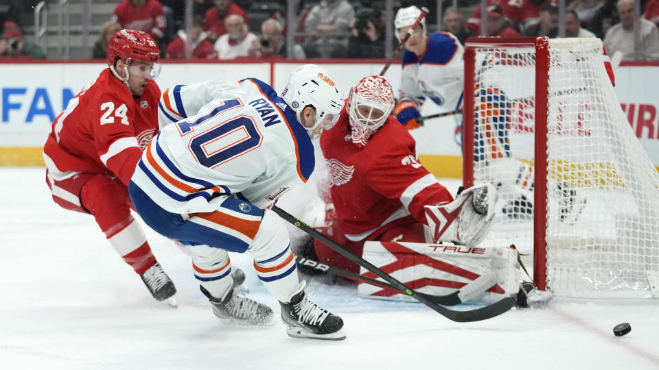 Detroit Red Wings goaltender Ville Husso (35) stops a Edmonton Oilers center Derek Ryan (10) shot as \Pius Suter (24) defends in the first period of an NHL hockey game Tuesday, Feb. 7, 2023, in Detroit. (AP Photo/Paul Sancya)