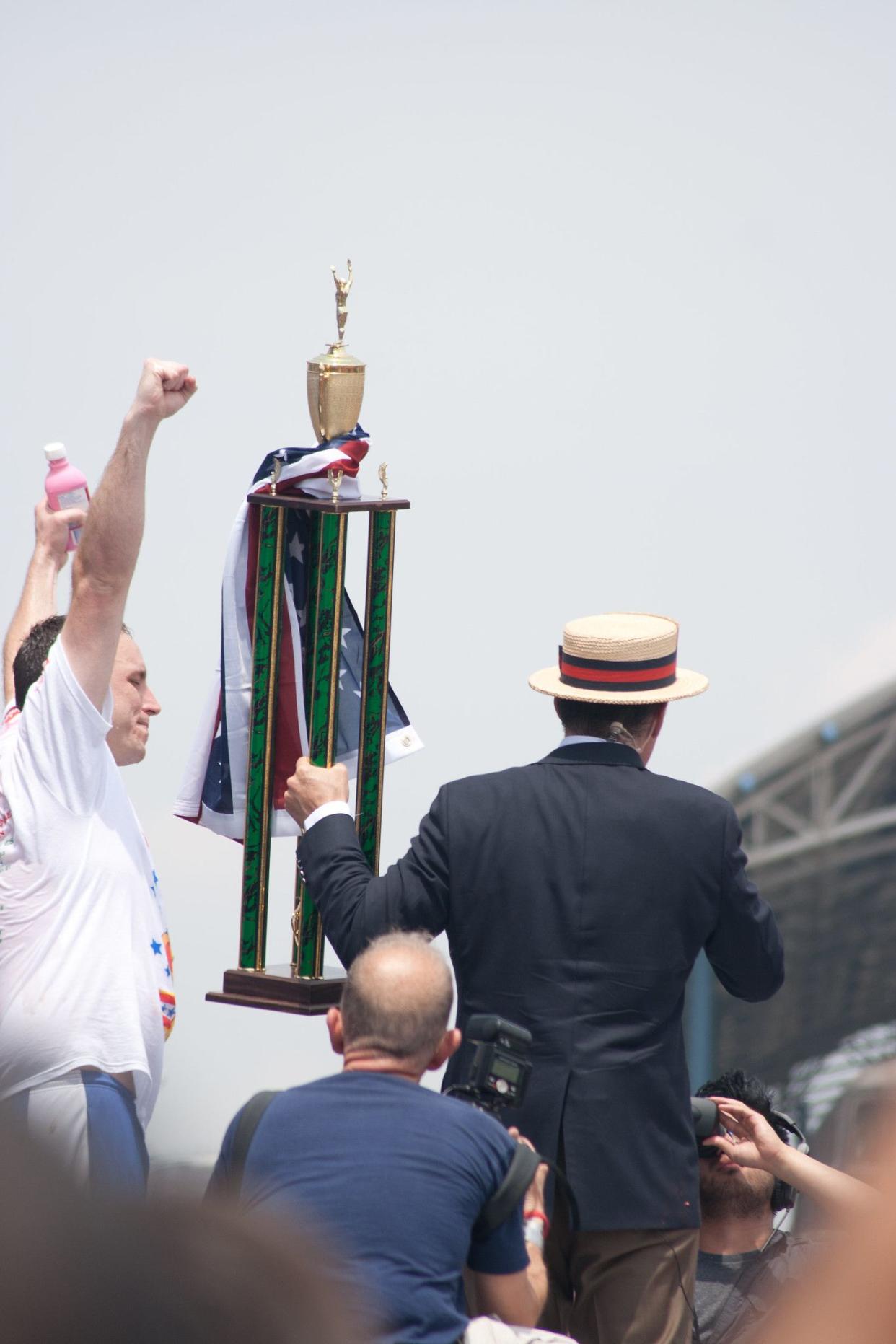 Joey Chestnut winning a trophy at an eating competition.