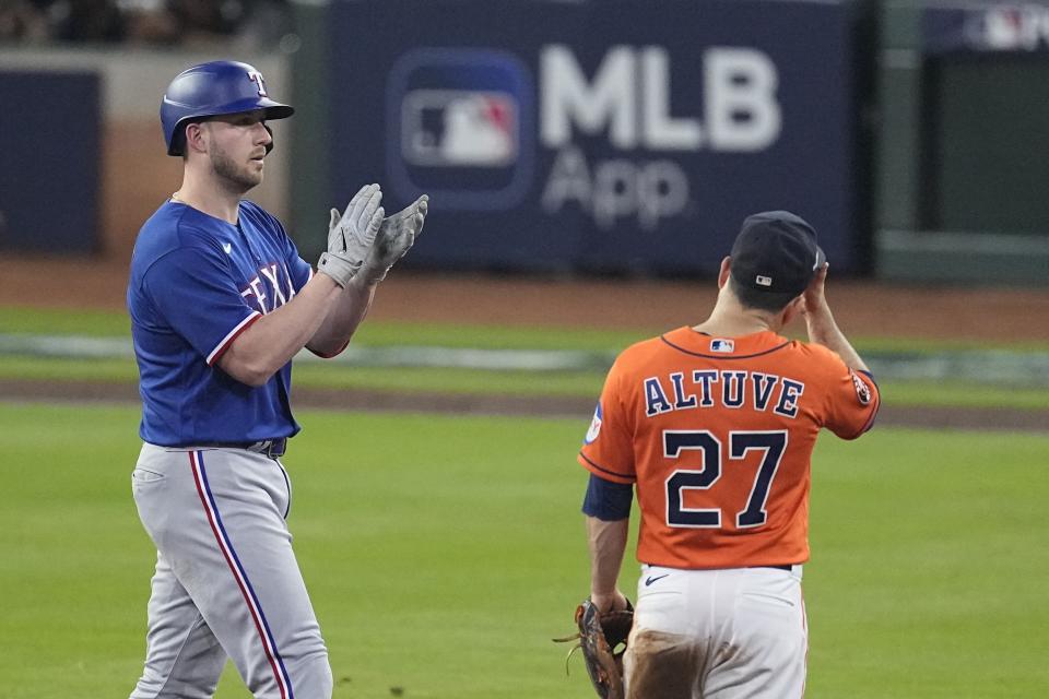 Texas Rangers' Mitch Garver reacts after hitting an RBI double during the eighth inning of Game 6 of the baseball AL Championship Series against the Houston Astros Sunday, Oct. 22, 2023, in Houston. (AP Photo/Tony Gutierrez)
