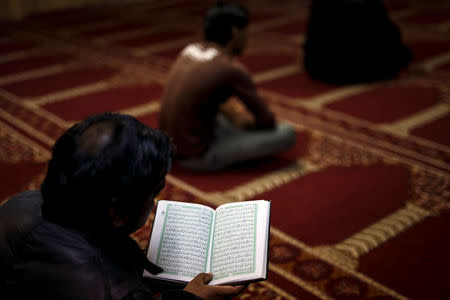 A Muslim living in Greece reads the Koran before Friday prayers at the Masjid Al-Salam makeshift mosque in Athens, Greece, February 3, 2017. REUTERS/Alkis Konstantinidis