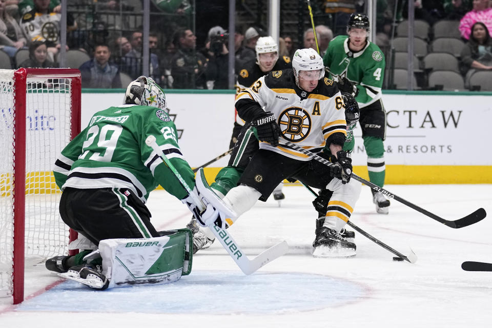 Dallas Stars goaltender Jake Oettinger (29) defends as Boston Bruins left wing Brad Marchand (63) attempts to take a shot in the second period of an NHL hockey game, Tuesday, Feb. 14, 2023, in Dallas. (AP Photo/Tony Gutierrez)