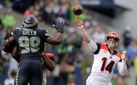 Cincinnati Bengals quarterback Andy Dalton (14) passes under pressure from Seattle Seahawks defensive end Rasheem Green (98) during the second half of an NFL football game Sunday, Sept. 8, 2019, in Seattle - Credit: AP