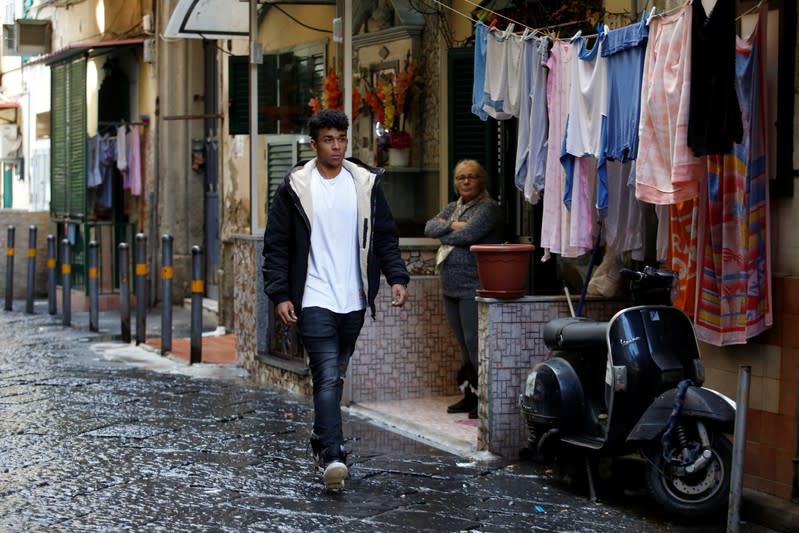 Nico Rodrigues, 21, walks on the street, close to the Santa Maria della Sanita Basilica in the Rione Sanita neighbourhood, in Naples