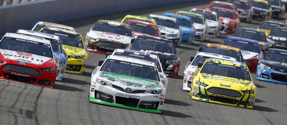 Kyle Busch (18) leads the pack during a restart after a caution flag during the NASCAR Sprint Series auto race in Fontana, Calif., Sunday, March 23, 2014. Busch won the race. (AP Photo/Alex Gallardo)