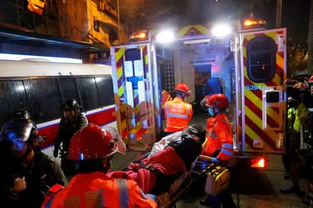 Paramedics escort an injured anti-extradition bill demonstrator in an ambulance after he was detained by police officers during a protest in Hong Kong