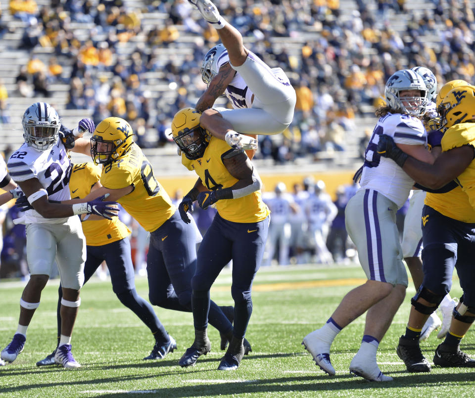 Kansas State defensive back Kiondre Thomas (3) leaps over West Virginia running back Leddie Brown (4) as he attempts to block a pass during an NCAA college football game Saturday, Oct. 31, 2020, in Morgantown, W.Va. (William Wotring/The Dominion-Post via AP)