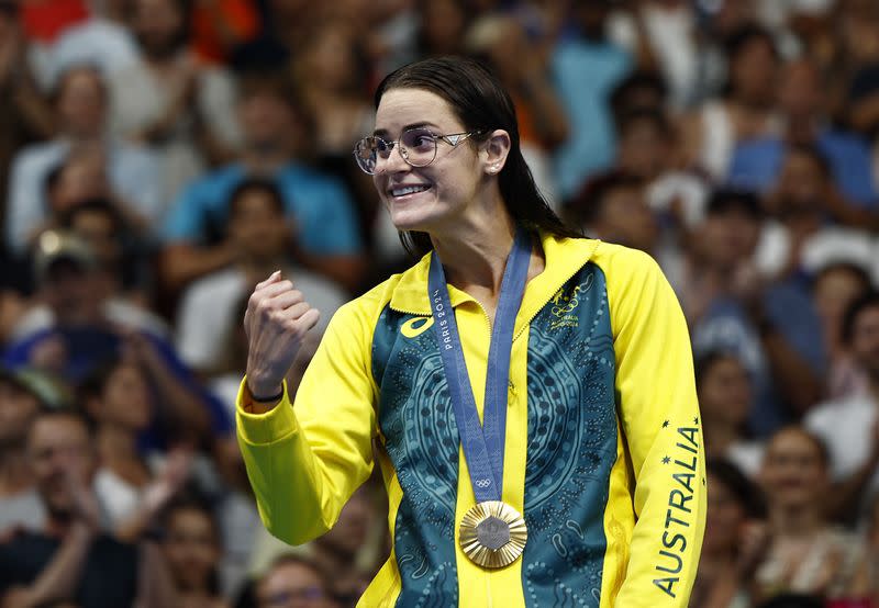 La medallista de oro Kaylee McKeown de Australia celebra en el podio después de ganar y establecer un récord olímpico en los 100 metros espalda femeninos, durante la Juegos Olímpicos de París en la piscina de La Defense, Naterre, Francia