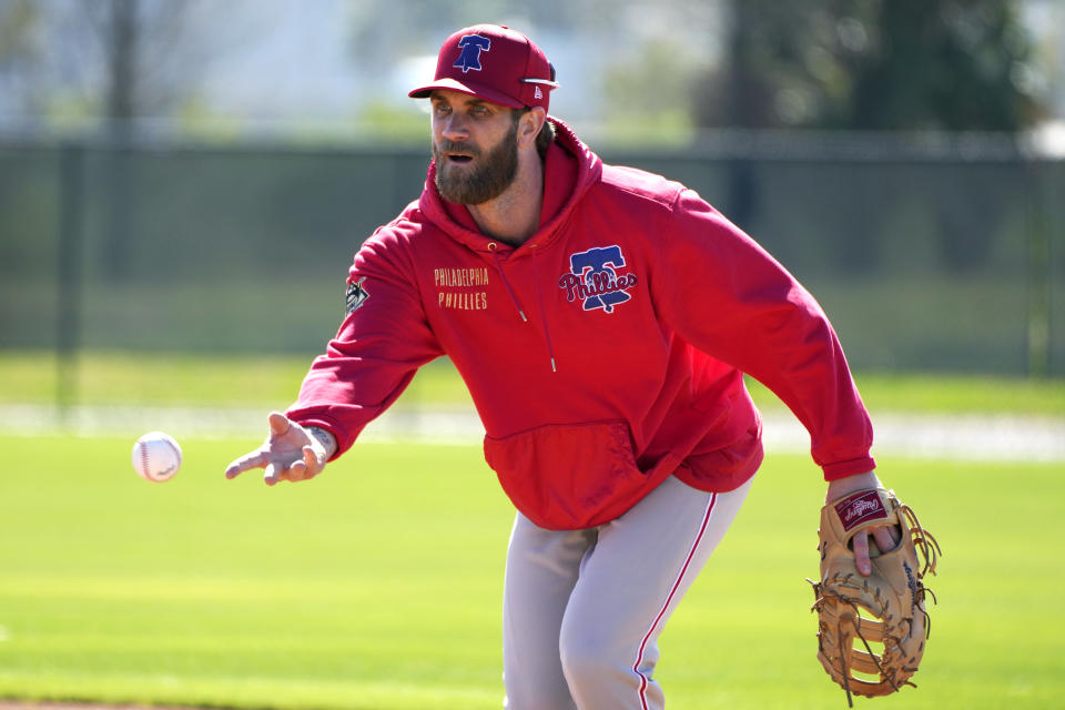 Philadelphia Phillies first baseman Bryce Harper throws to first base during a baseball spring training workout Monday, Feb. 19, 2024, in Clearwater, Fla. (AP Photo/Charlie Neibergall)