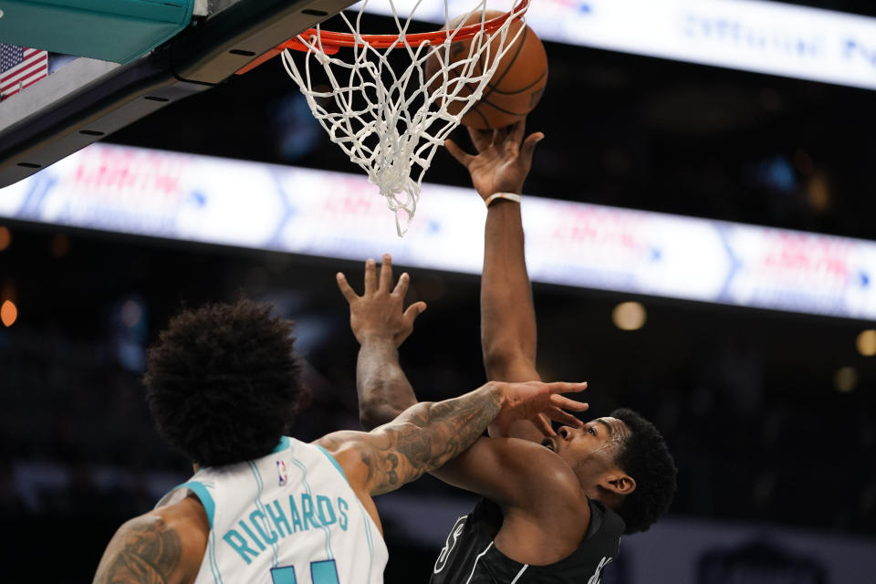 Brooklyn Nets center Day'Ron Sharpe, right, shoots the ball under pressure from Charlotte Hornets center Nick Richards in the first half of an NBA basketball game, Monday, Oct. 30, 2023, in Charlotte, N.C. (AP Photo/Erik Verduzco)