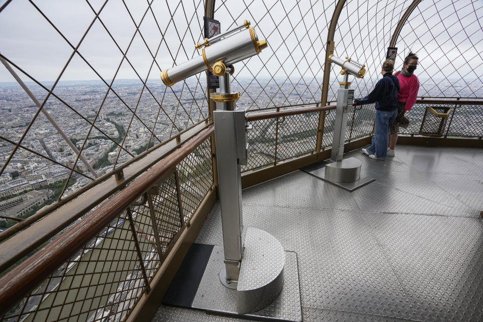 Visitors enjoy the view from top of the Eiffel Tower in Paris, Friday, July 16, 2021. The Eiffel Tower is reopening Friday for the first time in nine months, just as France faces new virus rules aimed at taming the fast-spreading delta variant. The "Iron Lady" was ordered shut in October as France battled its second surge of the virus. (AP Photo/Michel Euler)