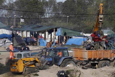 Workmen and heavy machinery continue to tear down makeshift shelters and tents in the "Jungle" during the dismantlement of the camp in Calais, France, October 27, 2016. REUTERS/Pascal Rossignol