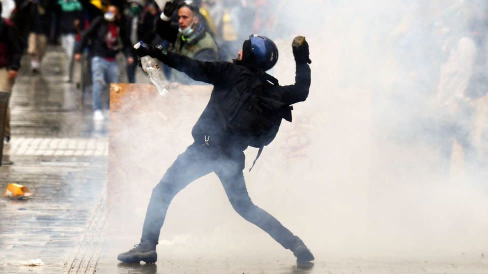 Un manifestante lanza una piedra durante las protestas de Colombia.