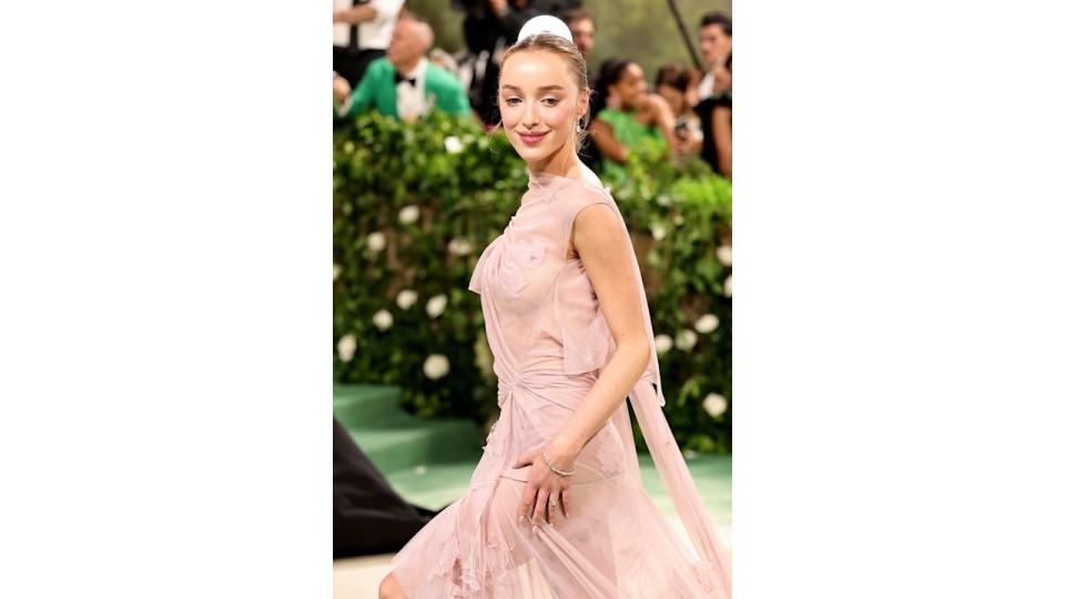 Phoebe Dynevor walks up stairs in pink dress