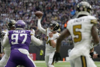 New Orleans Saints quarterback Andy Dalton (14) makes a pass to wide receiver Chris Olave (12) to score a touchdown during the second quarter of an NFL match between Minnesota Vikings and New Orleans Saints at the Tottenham Hotspur stadium in London, Sunday, Oct. 2, 2022. (AP Photo/Frank Augstein)