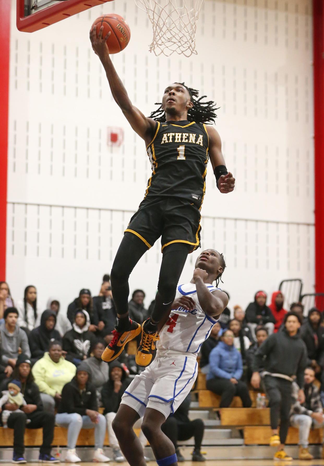Athena's Khorie Reaves drives in for two points over Monroe's Tajmir Mullins during their Section V boys basketball game.