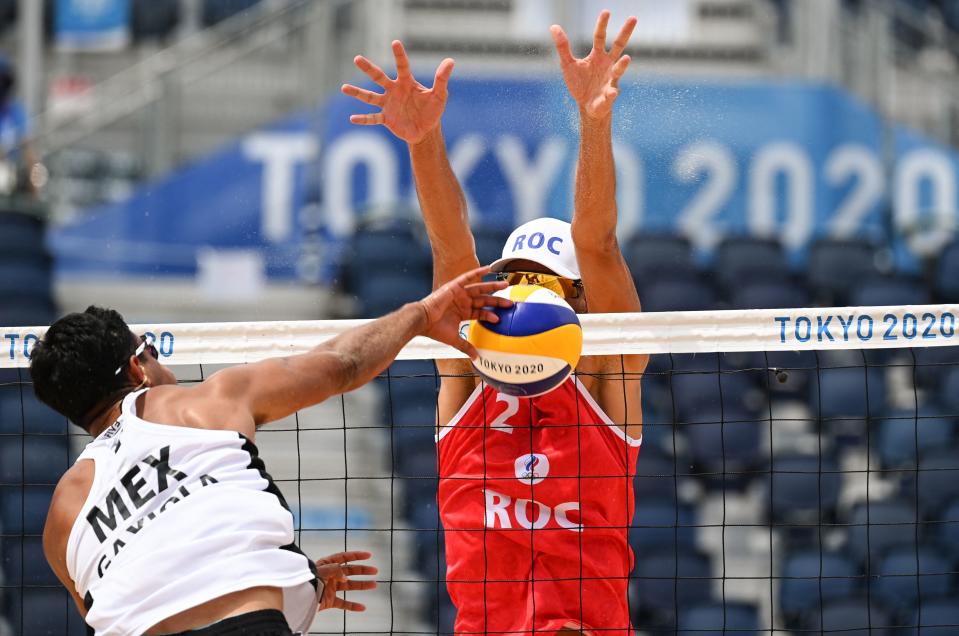 <p>Mexico's Josue Gaston Gaxiola Leyva attempts a shot past Russia's Oleg Stoyanovskiy in their men's preliminary beach volleyball pool B match between Russia and Mexico during the Tokyo 2020 Olympic Games at Shiokaze Park in Tokyo on July 26, 2021. (Photo by ANGELA WEISS / AFP)</p> 