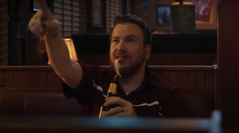 A costumer drinking a beer in a booth in "Support the Girls"