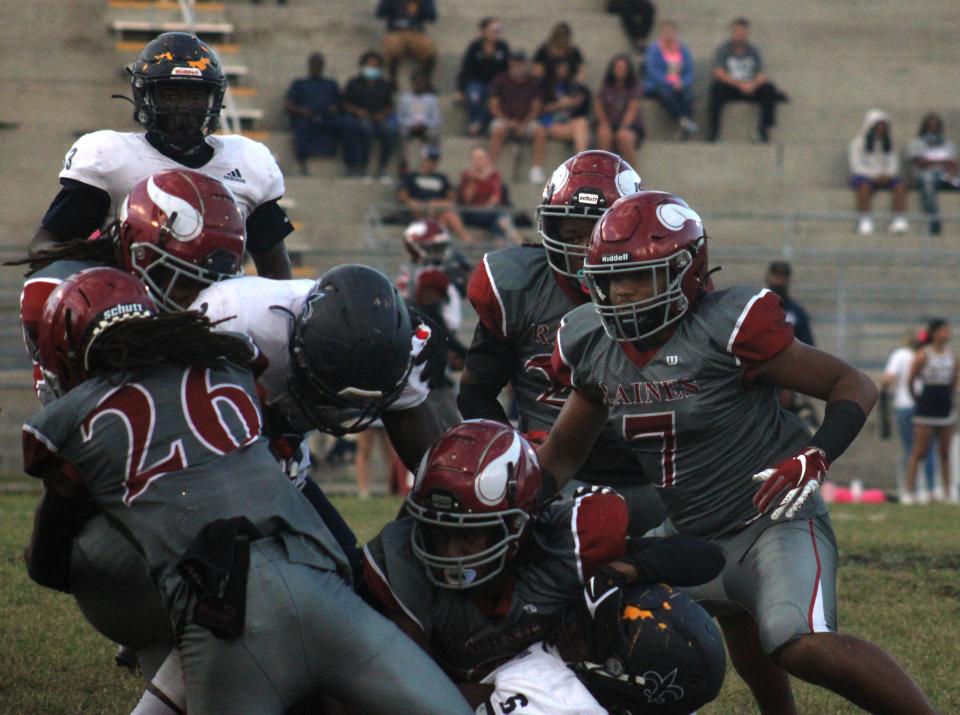 Sandalwood running back Jordan Bean (left) is wrapped up by a host of Raines defenders during the teams' 2021 game.