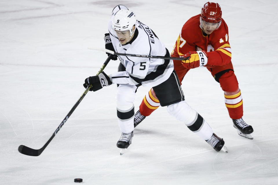 Los Angeles Kings defenseman Andreas Englund (5) is checked by Calgary Flames forward Yegor Sharangovich (17) during the second period of an NHL hockey game, Tuesday, Feb. 27, 2024 in Calgary, Alberta. (Jeff McIntosh/The Canadian Press via AP)
