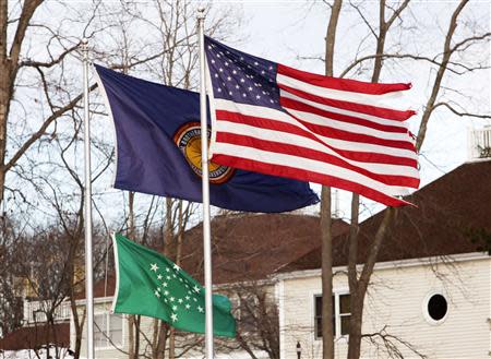 A flag in remembrance of the victims of the shootings at Sandy Hook Elementary School with 6 large and 20 small stars is seen with the U.S. and IBEW flags in Monroe, Connecticut December 13, 2013. REUTERS/Michelle McLoughlin